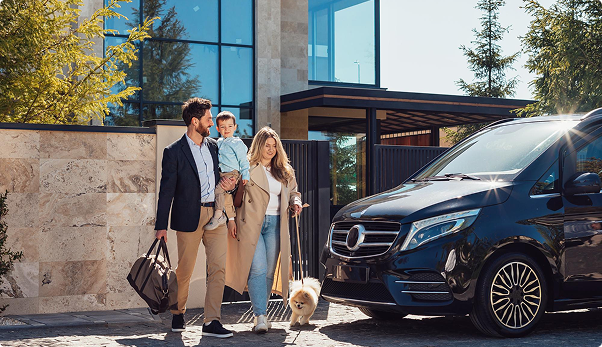 Family with child and dog next to a luxury Mercedes van