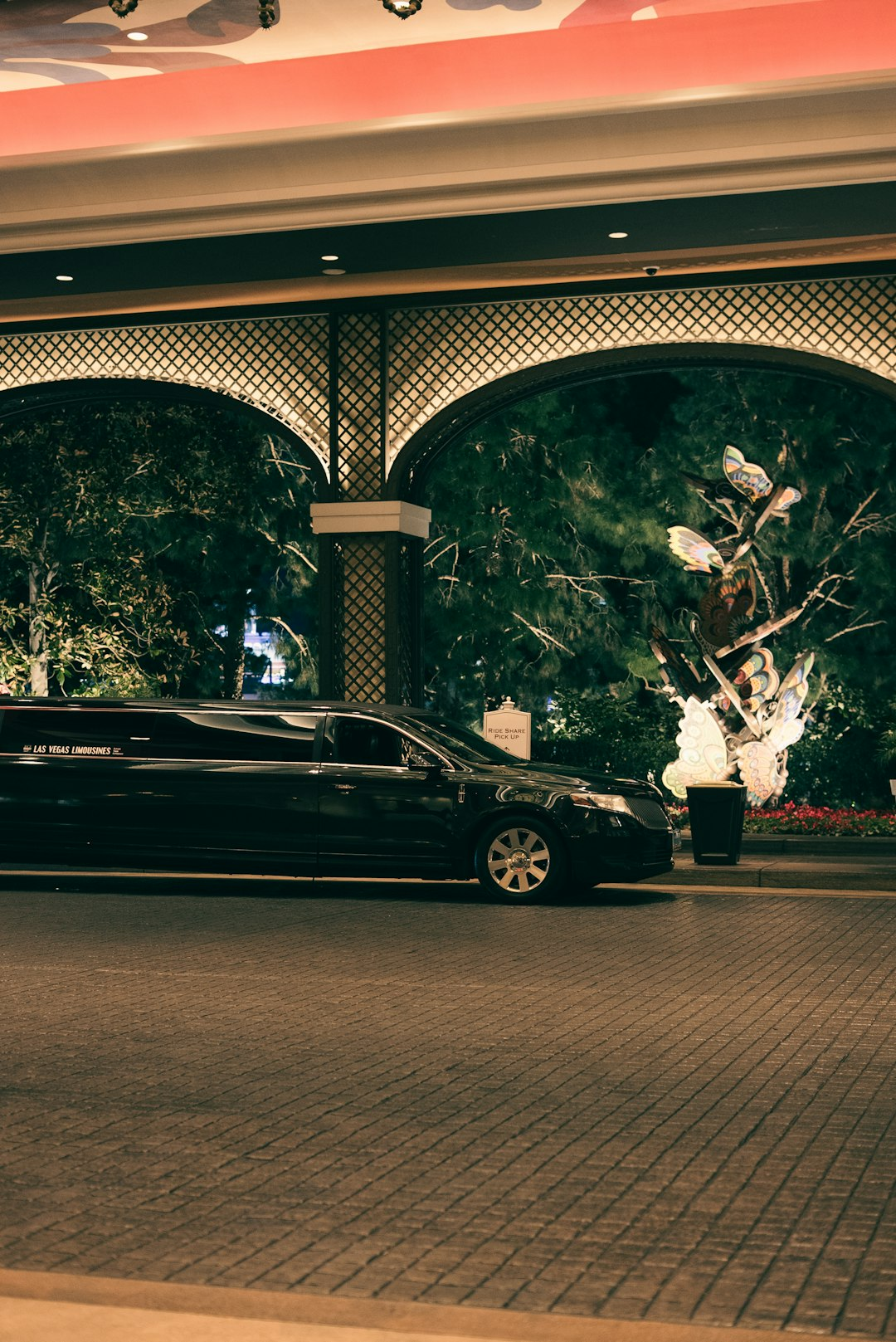 Black sedan waiting at a covered passenger pickup entrance