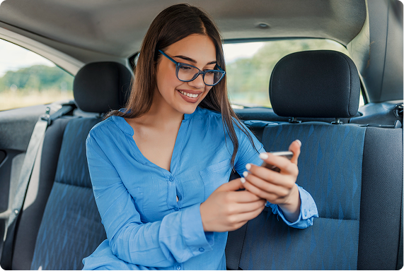 Passenger smiling while booking a ride from the back seat