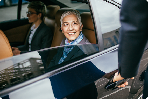 Smiling passenger in the back seat of a Prime Time Rideshare vehicle